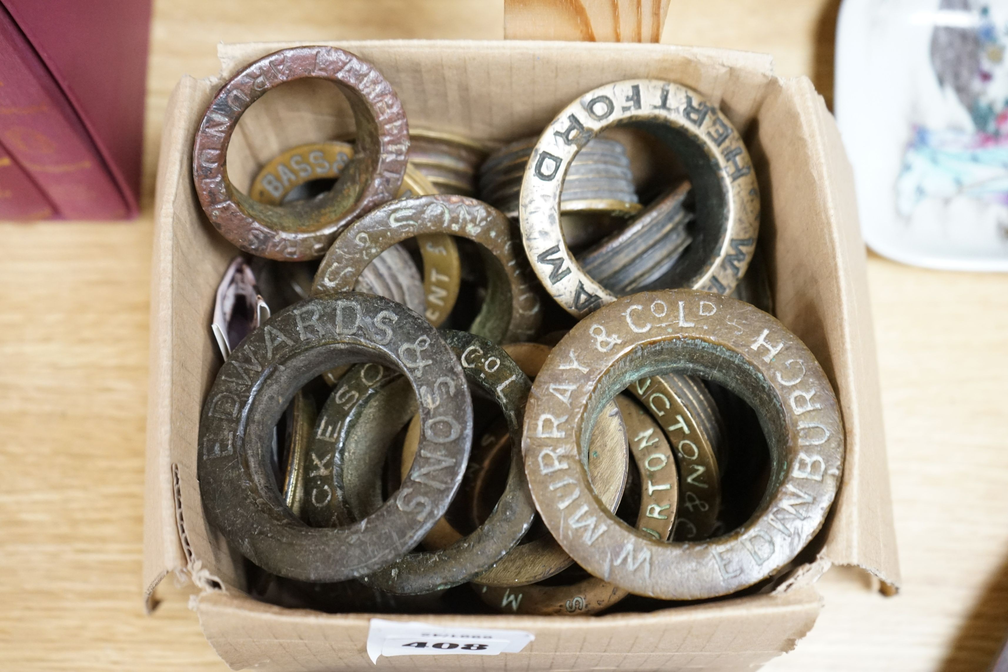 A collection of brass brewery bung collars and two cannon balls